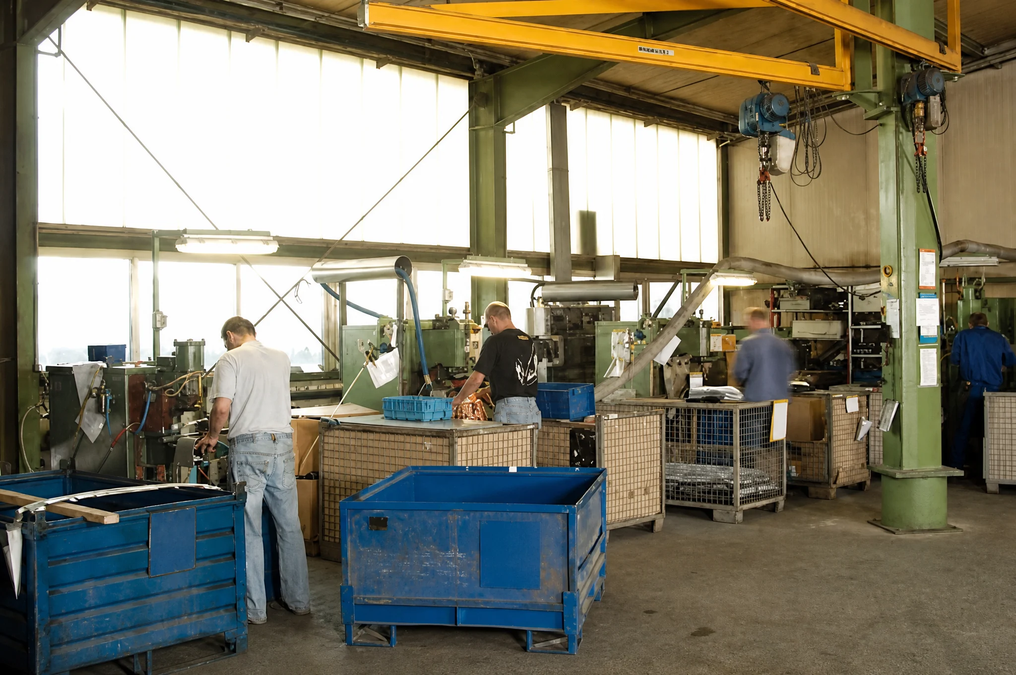 Punktschweißerei mit Arbeitsplätzen und blauen Gitterboxen